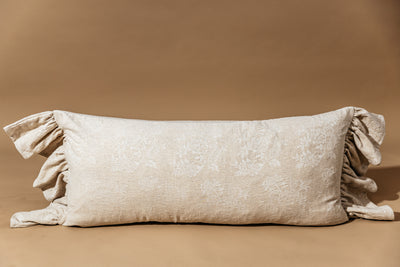 Floral embossed tan lumbar pillow on tan background