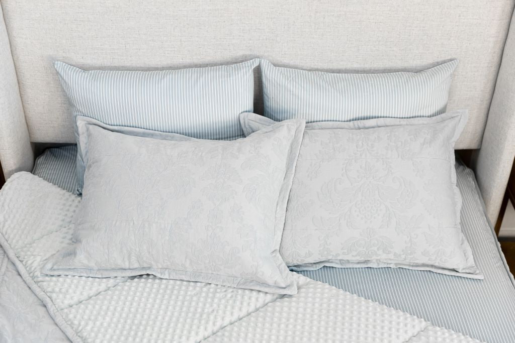 Overhead photo of blue floral zipper bedding with blue pinstripe sheets and light blue minky interior