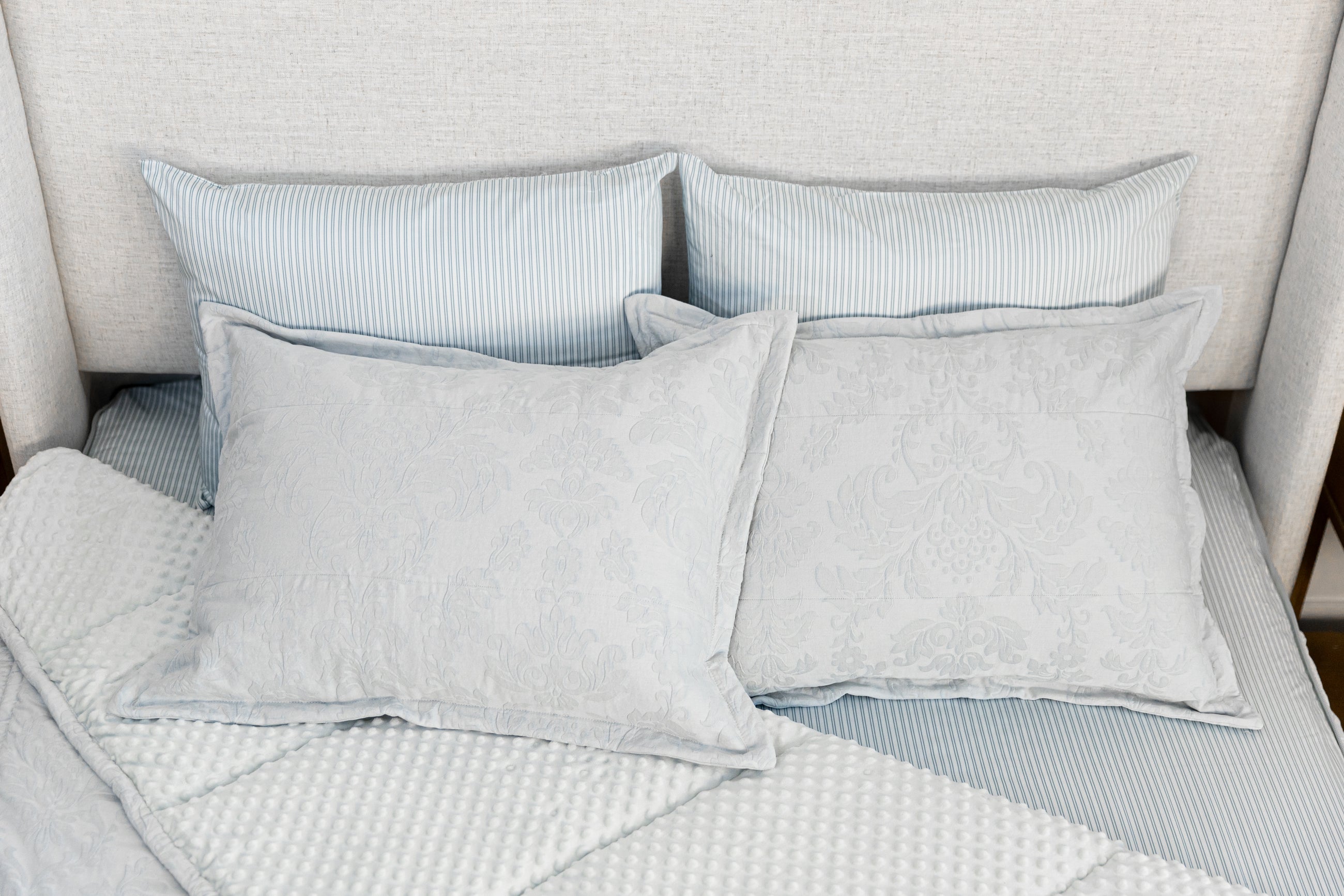 Overhead photo of blue floral zipper bedding with blue pinstripe sheets and light blue minky interior