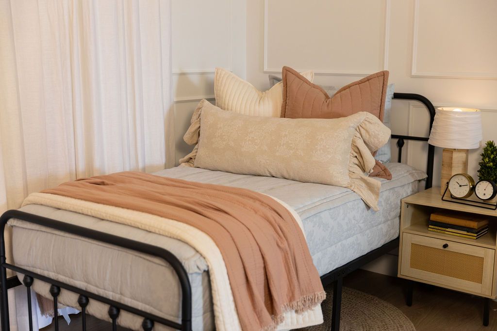 Twin bed with light blue floral zipper bedding with cream and terracotta accessories
