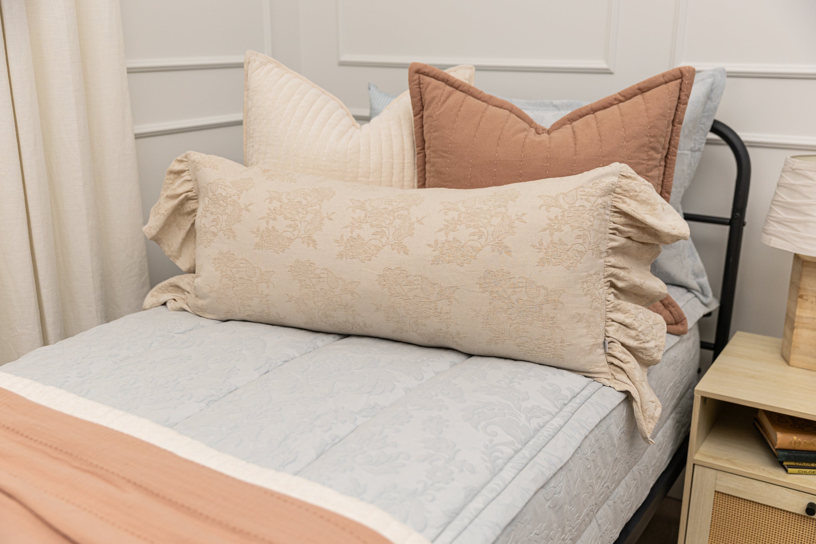 Twin bed with light blue floral zipper bedding with cream and terracotta accessories