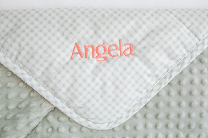 White and green custom embroidered mini blanket with pink stitching