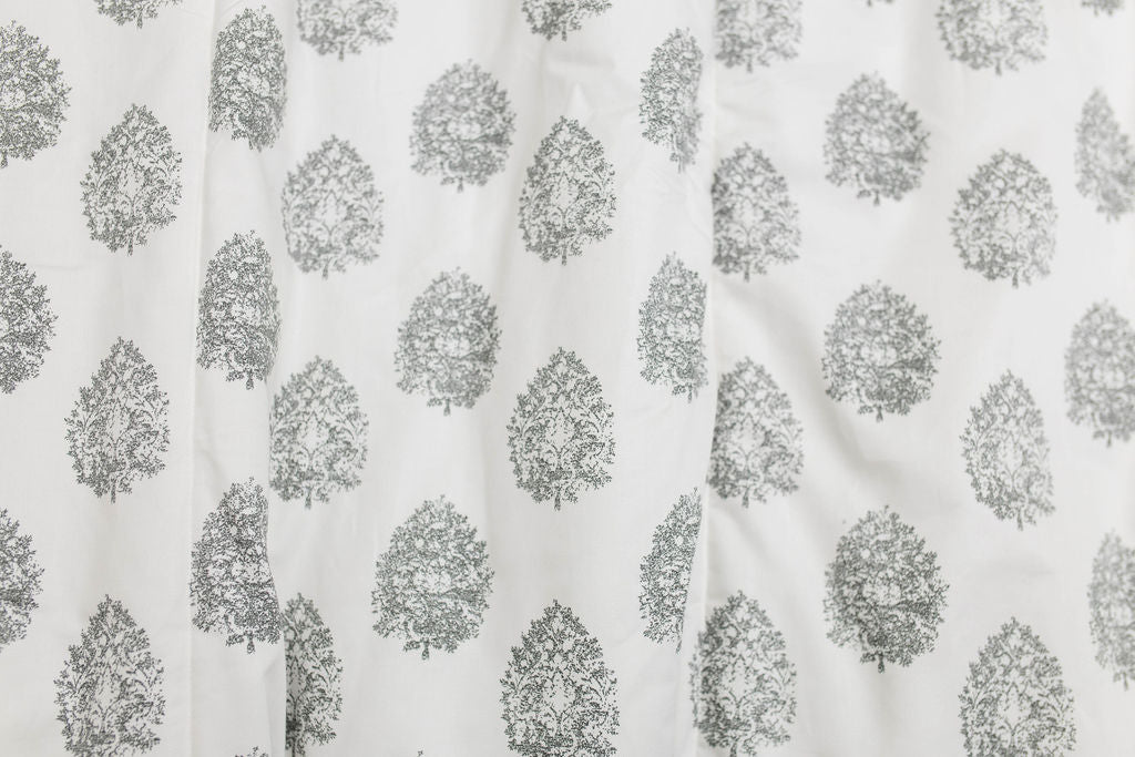 A close up view of a cream blanket with a gray floral design.