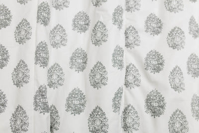 A close up view of a cream blanket with a gray floral design.