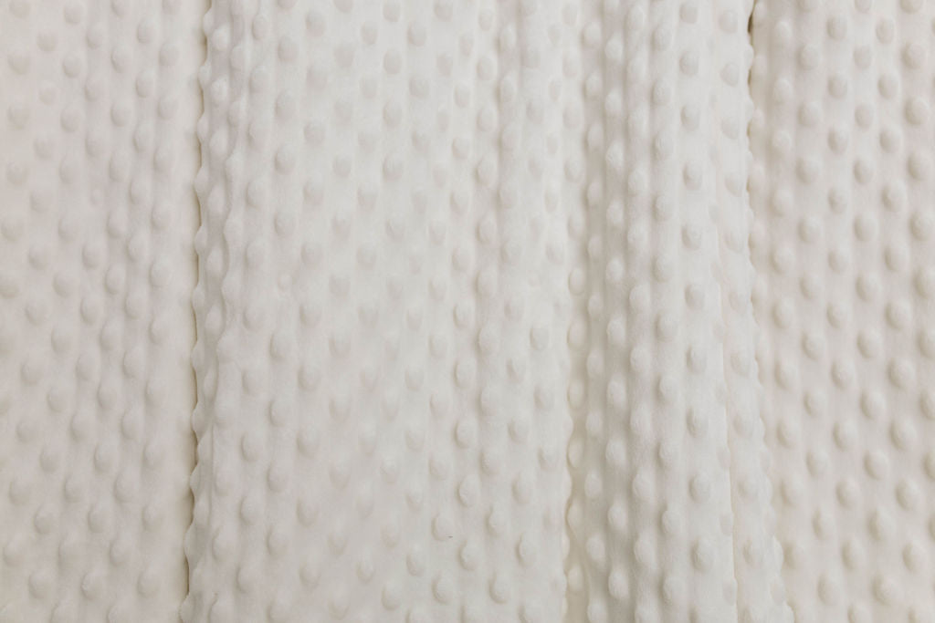 A close up view of a cream minky interior of a blanket.