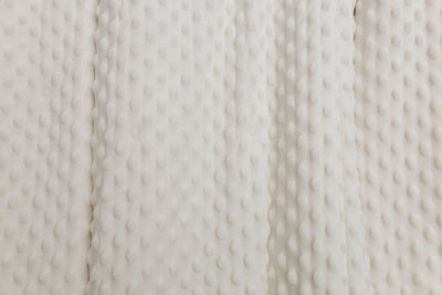 A close up view of a cream minky interior of a blanket.