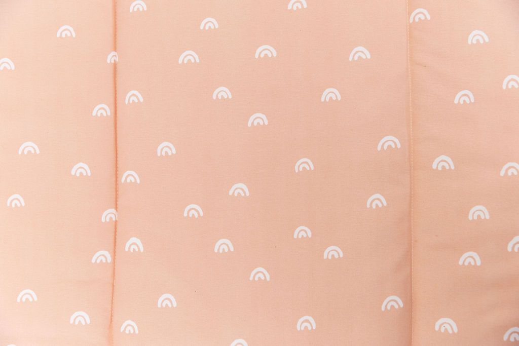 close up of peachy pink rainbow printed bedding