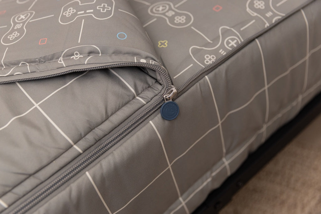A tight shot of the zipper feature on a set of gaming printed zipper bedding.