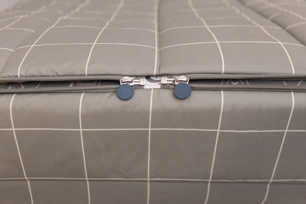 A shot of the two zippers on a set of gaming printed zipper bedding, the zippers completely unzipped to show how they meet at the foot of the bed.