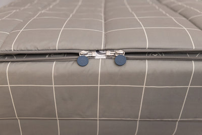 A shot of the two zippers on a set of gaming printed zipper bedding, the zippers completely unzipped to show how they meet at the foot of the bed.