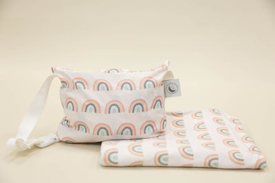 Kid travel blanket with rainbows and a coordinating pouch with a white strap.