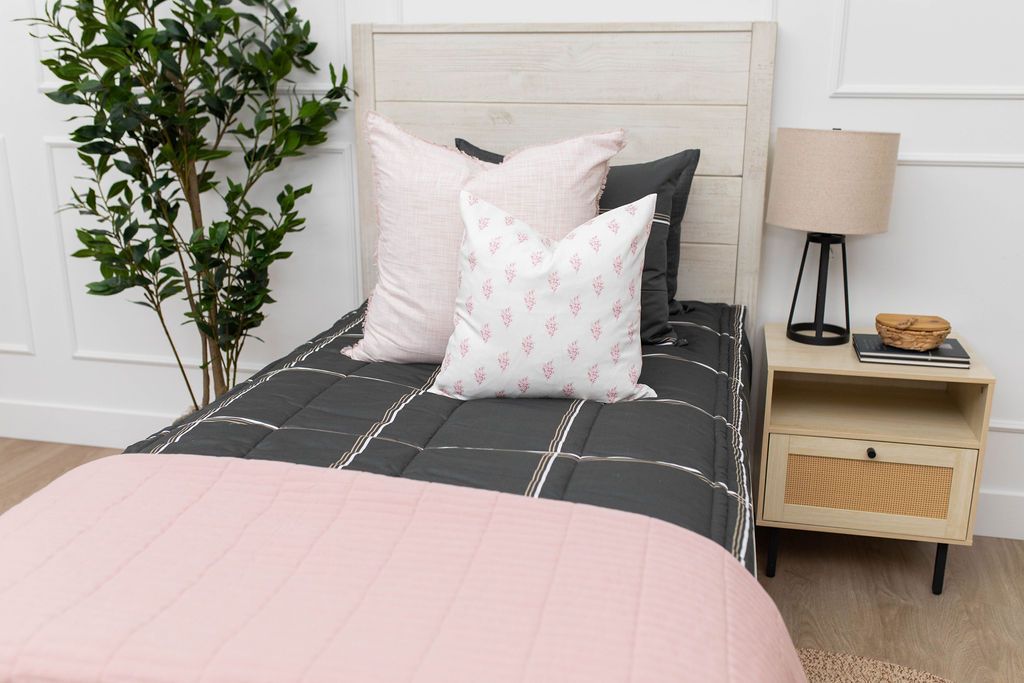 Pink floral pillow with pink euro and blanket on charcoal grid patterned zipper bedding