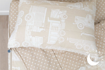 A twin bed made with light tan cars kids zipper bedding, the top unzipped and slightly pulled back and a pillow on the bed.
