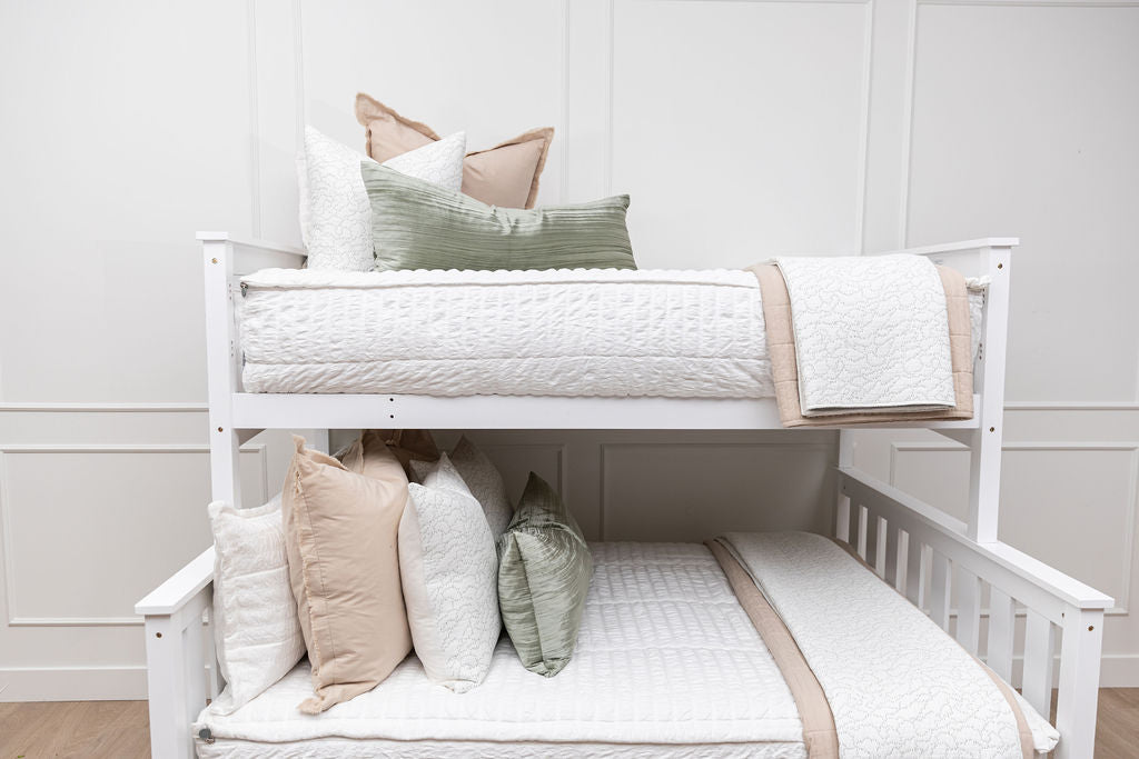 a standard bunk bed with both bunks made with seersucker white zipper bedding and neutral and green pillows and blankets.