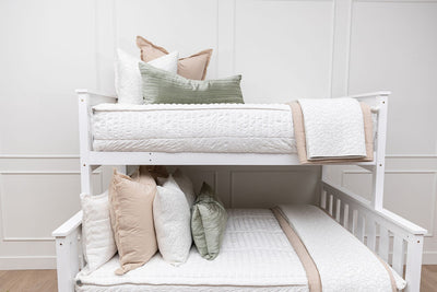 a standard bunk bed with both bunks made with seersucker white zipper bedding and neutral and green pillows and blankets.