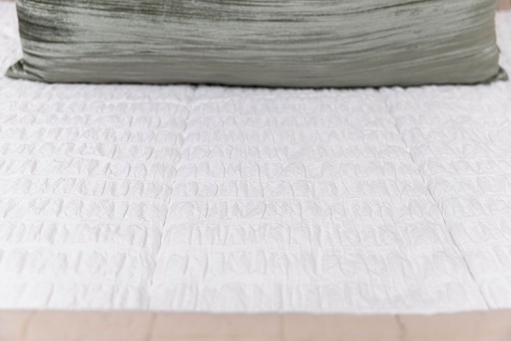 A close up of the seersucker detail on white zipper bedding.
