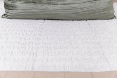 A close up of the seersucker detail on white zipper bedding.