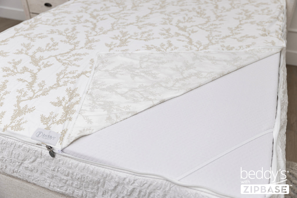 A ZipBase sheet partially unzipped and pulled back to show how it detaches from the rest of the base sheet wrapped around the sides of the mattress.