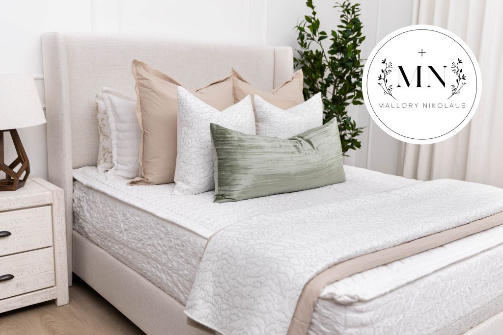 A queen bed made with white seersucker zipper bedding and an assortment of neutral bedding accessories, designed by interior designer Mallory Nkolaus