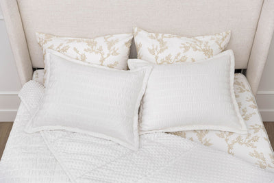 Aerial view of a bed made with white seersucker zipper bedding, the top pulled back to reveal the minky lining, two pillowcases and two shams on top of the bed
