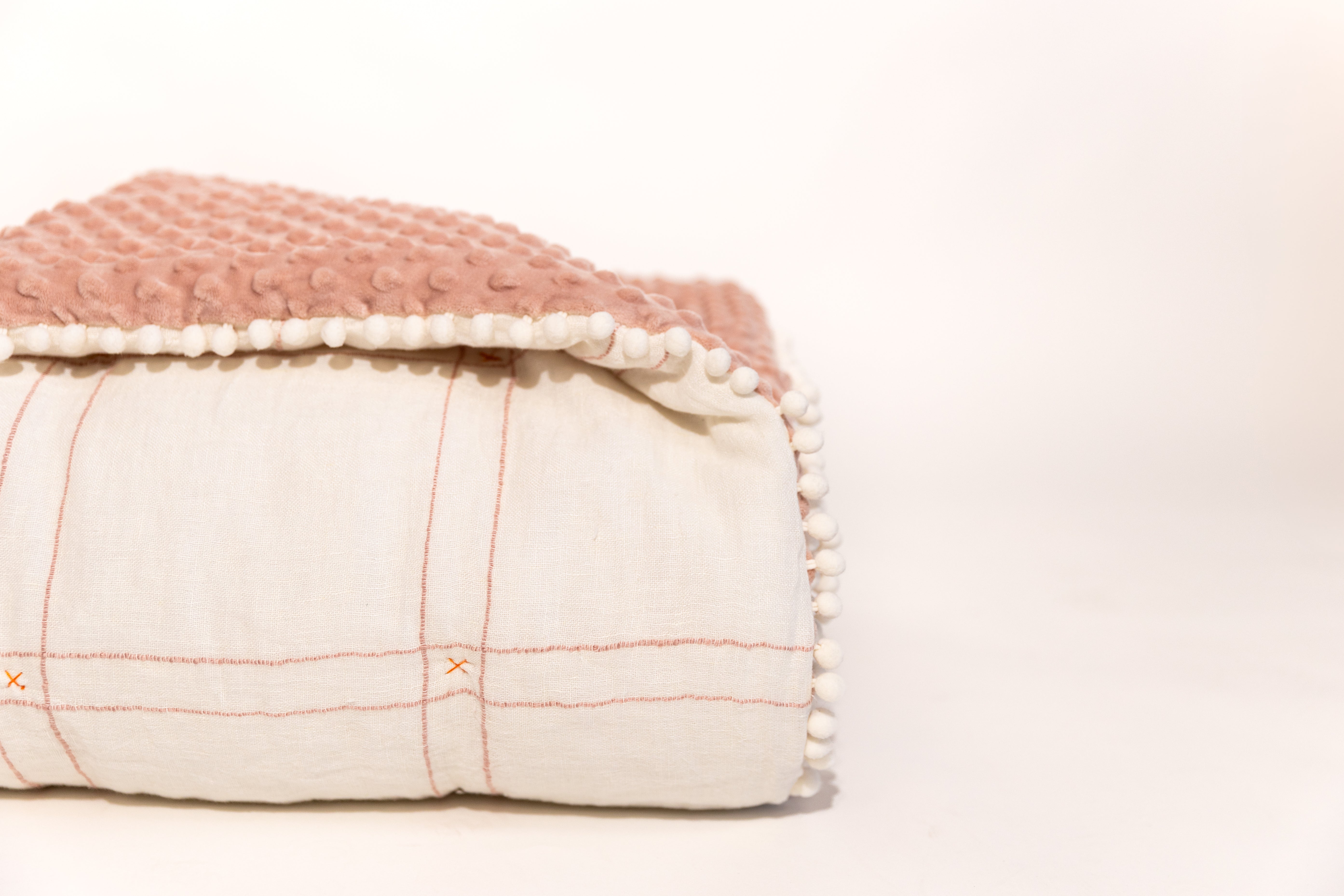 White background photo of white and pink blanket