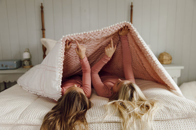 Two girls pointing at pink minky side of blanket