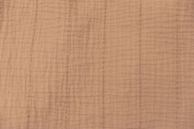 Close up on the terra cotta color of a seersucker throw blanket