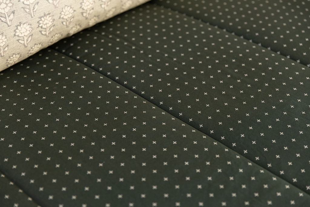 A close up view of the exterior pattern of a dark green zipper bedding.