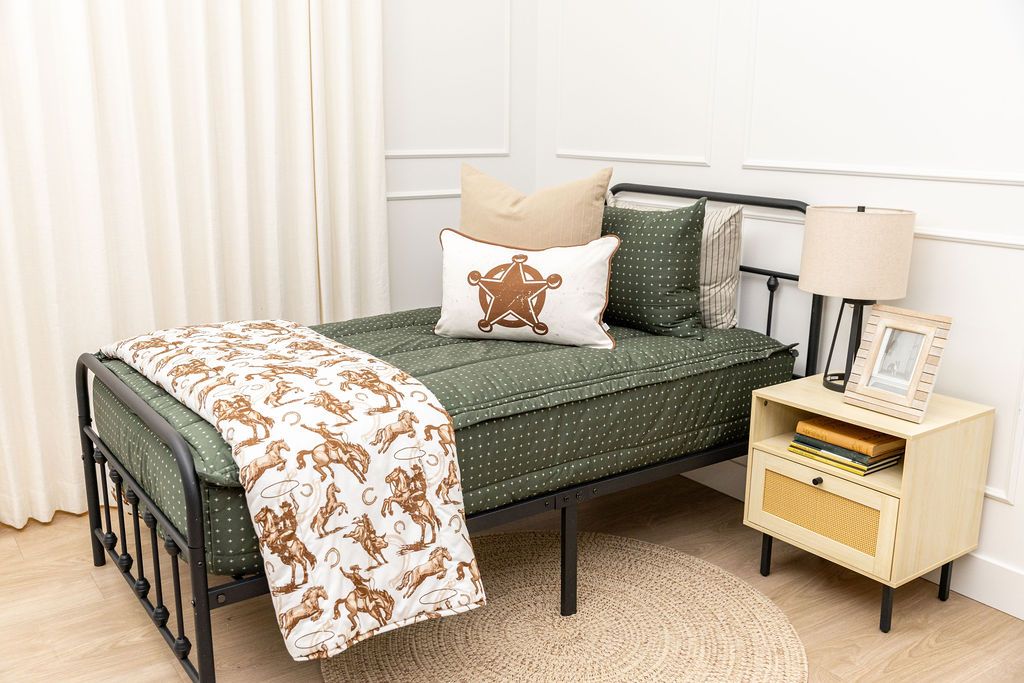 twin bed with Dark green zipper bedding with small cross design paited with tan and white western accessories