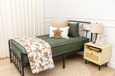 twin bed with Dark green zipper bedding with small cross design paited with tan and white western accessories