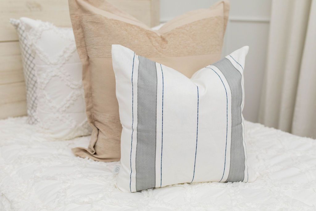 Gray and white striped pillow and blanket on white zipper bedding