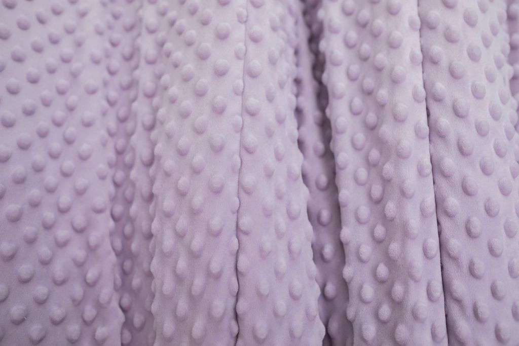 A close up of a light purple softly textured minky blanket. 