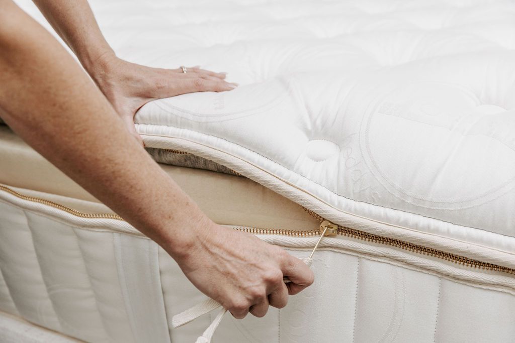 Someone pulling the zipper on a zipper mattress.