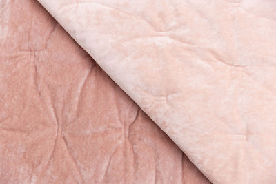 A pink velvet dual sided blanket, one side with a deep pink and one side in a light pink