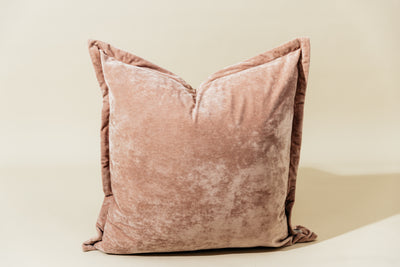 A pink velvet euro pillow arranged on a cream background.