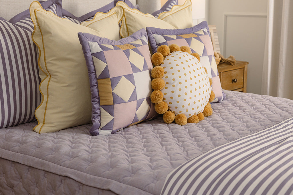 A close up photo of puffed, purple zipper bedding.