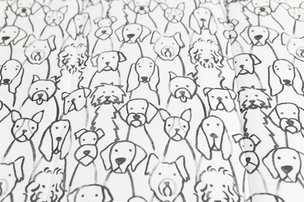 A close up of the print on a set of charcoal and white pattern dogs kids zipper bedding.