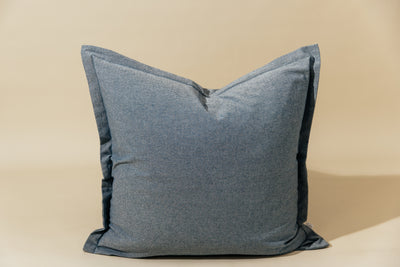 A blue two-toned herringbone euro pillow arranged on a cream background.