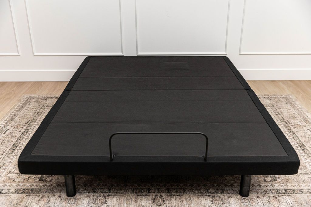 An adjustable base with no mattress and the head and foot of the base positioned all the way down.