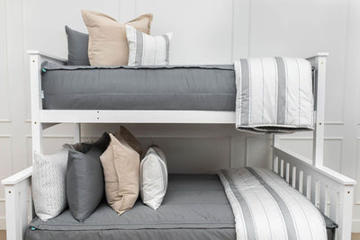 A standard bunk bed with both bunks made with gray zipper bedding and neutral and gray striped pillows and blankets.