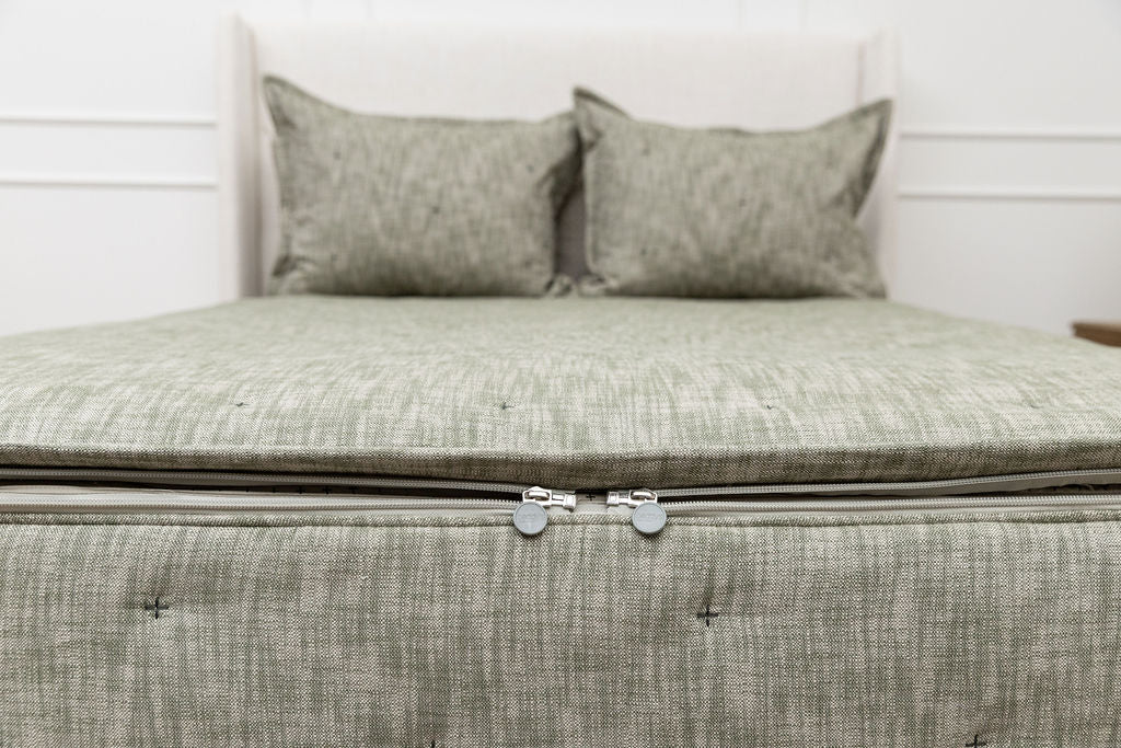 The foot of a bed made with deep emerald green zipper bedding showing where the two zippers are located.