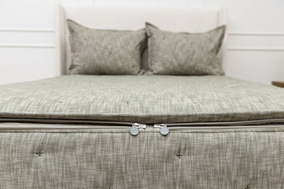 The foot of a bed made with deep emerald green zipper bedding showing where the two zippers are located.