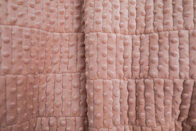A close up of a softly textured pink minky blanket.
