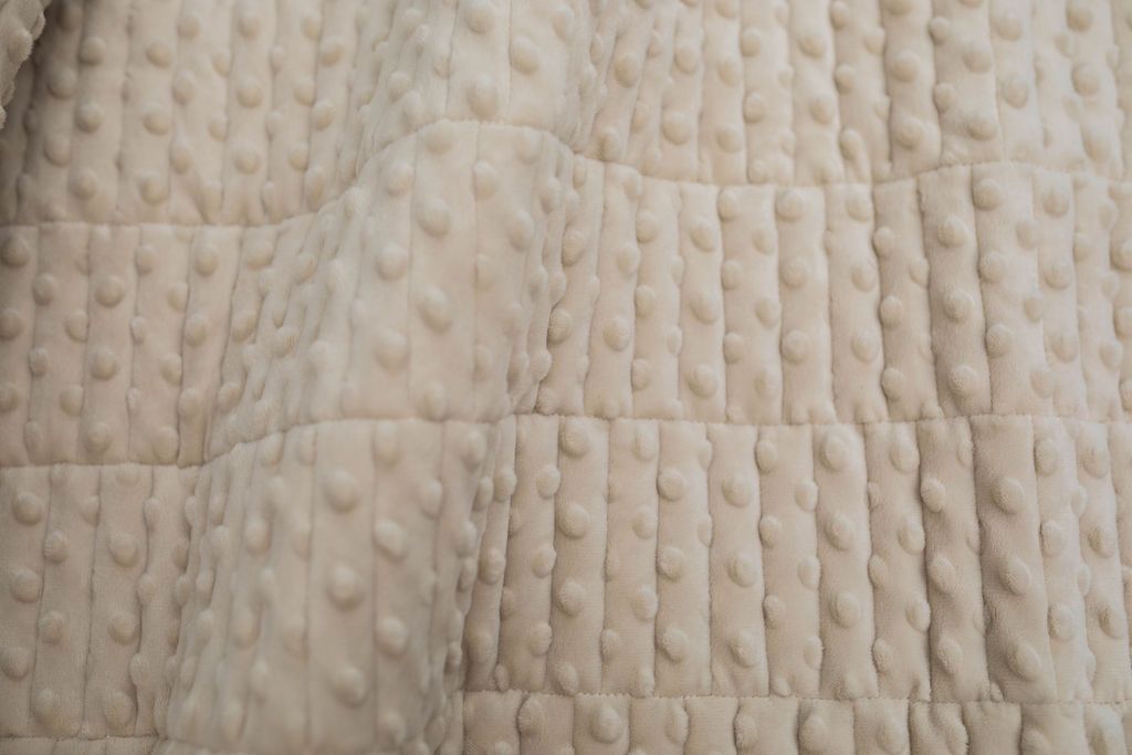 A close up view of a tan soft minky blanket.