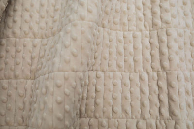 A close up view of a tan soft minky blanket.