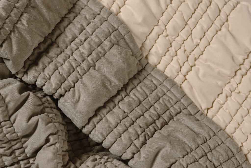 Photo that shows both sage green and cream scrunched blanket. 