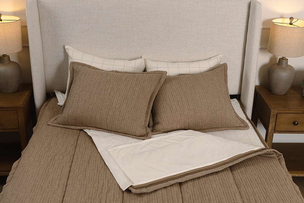 Overhead photo of tan woven zipper bedding with cream and cream and tan plaid bed sheets and cream corduroy minky interior.