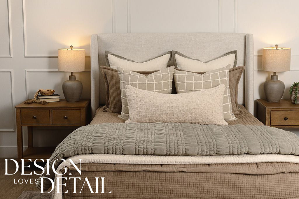 Tan woven quilted bedding with cream and green accessories. 