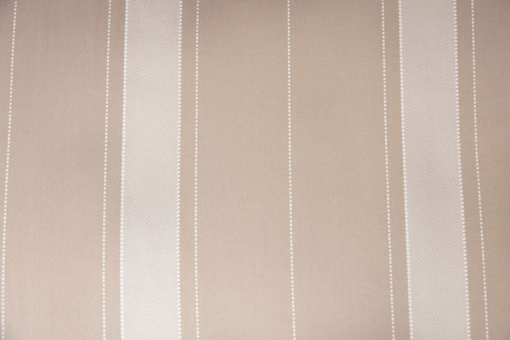 A close up view of a tan striped interior of a tan zipper bedding.