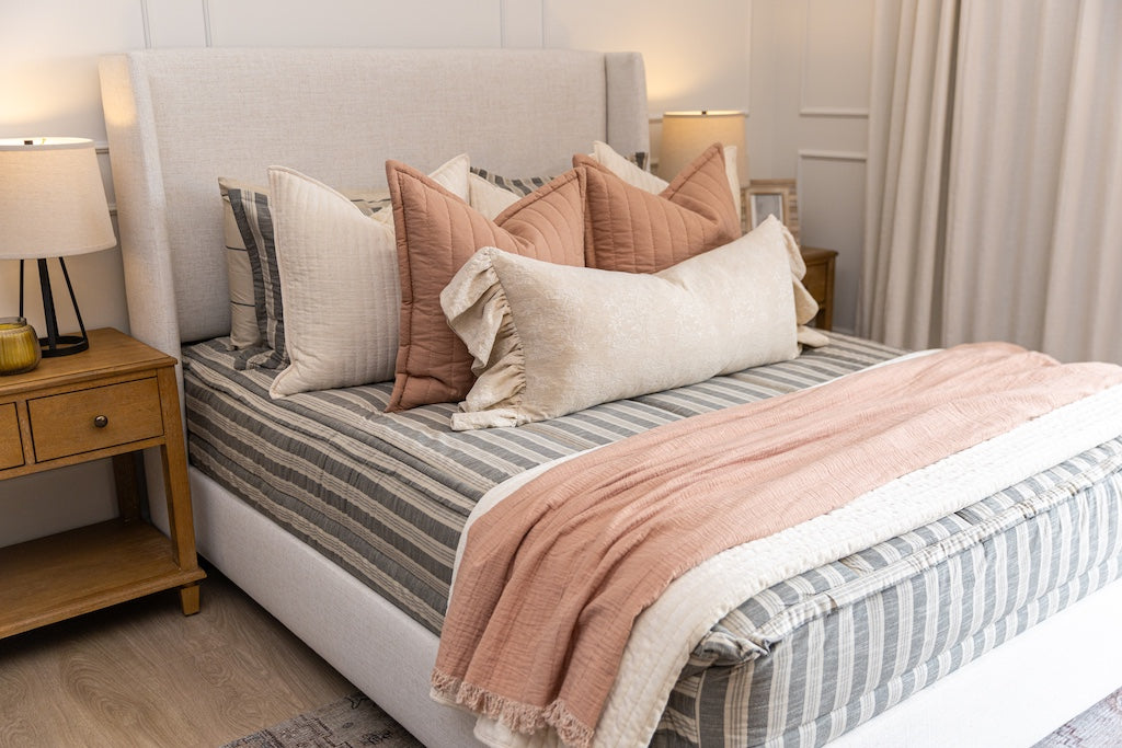 Classic neutral stripe zipper bedding with cream and terracotta accessories.